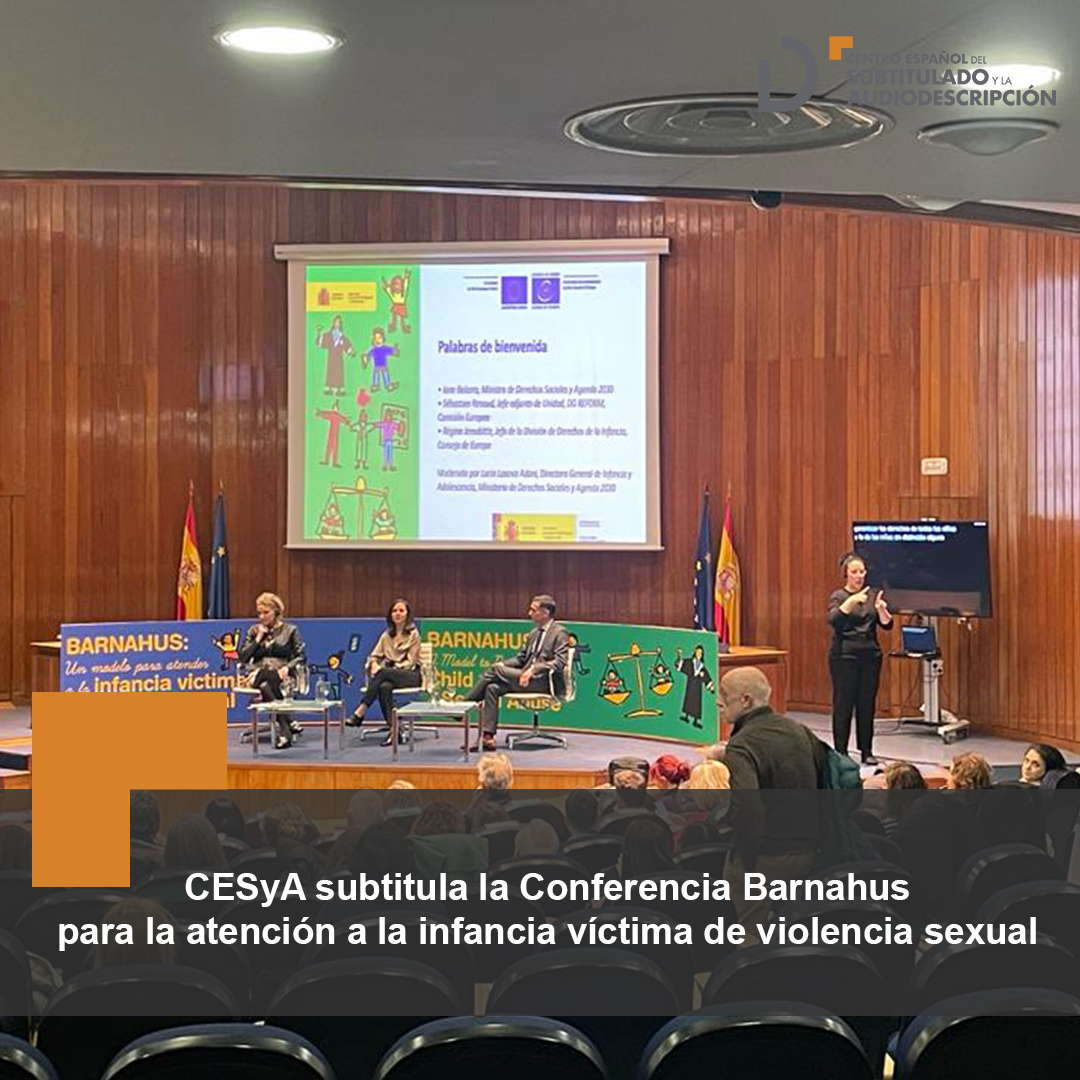Panorámica del escenario donde se encuentran dos ponentes junto a la ministra Ione Belarra. a la derecha se encuentra la pantalla de proyección de subtitulado y la intérprete de lengua de signos. 
