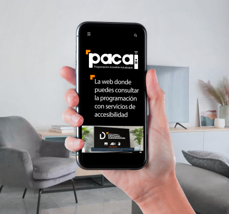 Una mano sostiene un teléfono móvil y en la pantalla aparece la página principal de programación accesible actualizada.